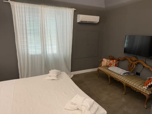 Camera moderna di Palco Rooms&Suites a Palermo con letto, panchetta in legno, TV, aria condizionata e vista città