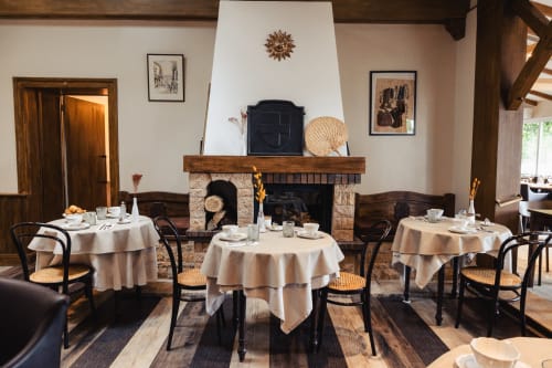 Élégante salle à manger du Savoy Hôtel avec tables rondes, cheminée et décor classique au Bourget-du-Lac