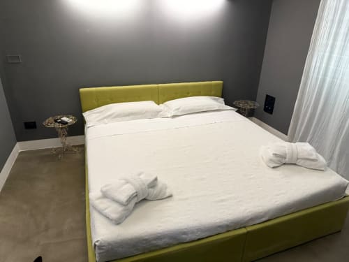 Camera moderna a Palco Rooms&Suites a Palermo con letto rivestito in verde lime, biancheria bianca e pareti grigie