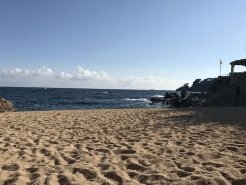 Plage de sable fin avec mer turquoise et côte rocheuse à Palafrugell, appartement en front de mer avec vue sur l'océan