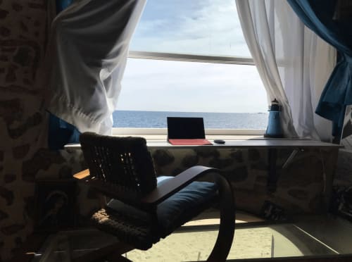 Espace de travail d'un appartement en bord de mer avec vue sur l'océan, ordinateur portable à un bureau près de la fenêtre, Palafrugell, Espagne