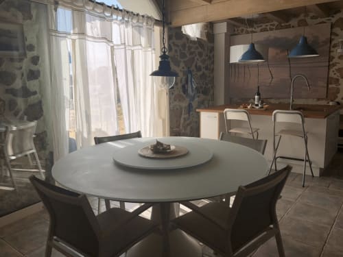 Salle à manger moderne à Finques Garcia Enrich, Palafrugell avec table ronde blanche, chaises noires, vue mer et accès à la cuisine