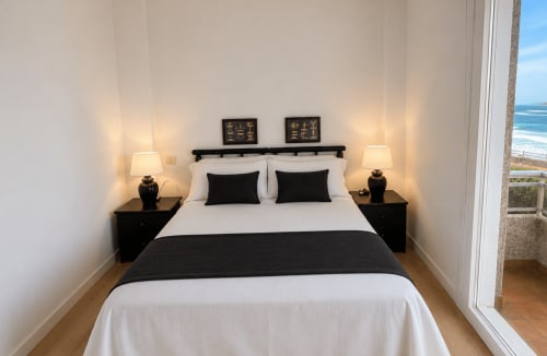 Habitación moderna con vistas al mar en Holibai, Baiona, con cama queen, mesitas negras y vista oceánica desde el balcón