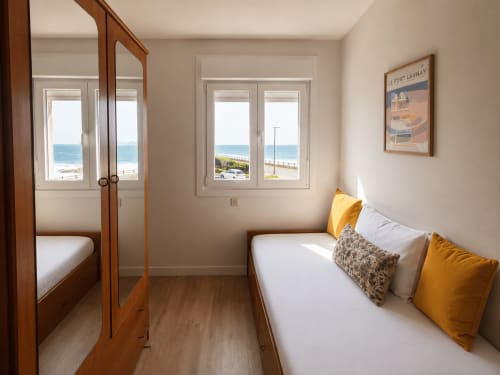 Dormitorio luminoso con vistas al mar en el apartamento As Estelas de Baiona, España, con cama doble y armario con espejo