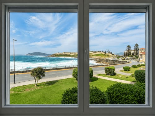 Vistas al mar desde el balcón del apartamento As Estelas en Baiona, España, mostrando playa, carretera costera y océano azul