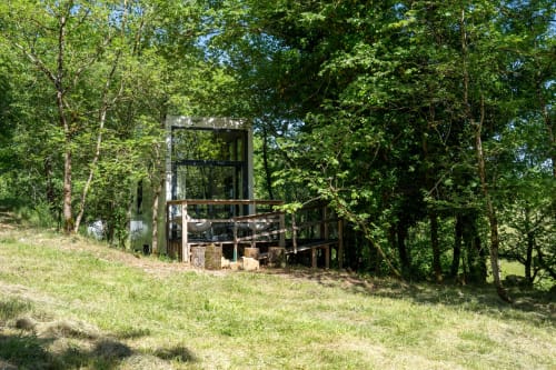 Cabane perchée rustique aux cabanes de Julie, nichée en forêt de Boussac avec terrasse en bois et verdure environnante