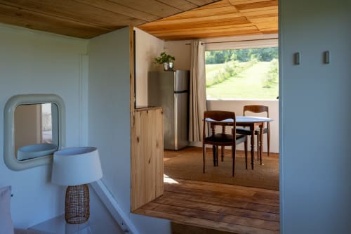 Intérieur moderne de cabane aux Cabanes de Julie avec cuisine, salle à manger et vue sur le jardin par de grandes fenêtres