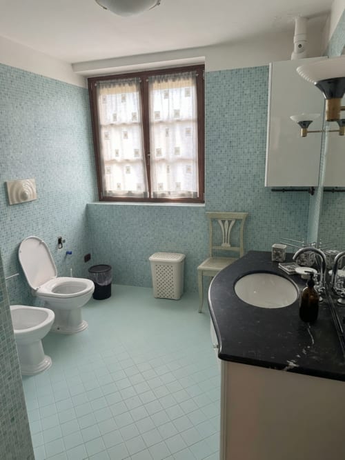 Bagno moderno nella camera Ulivo dell'Agriturismo Colle Mura, Gualdo Tadino, con piastrelle blu chiaro e lavabo nero