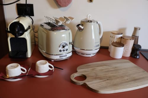 Angolo caffè e cucina in appartamento Tagasuites 107, Catania con macchina espresso, bollitore e tagliere