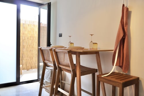 Moderna zona pranzo dell'appartamento Tagasuites a Catania con tavolo in legno, sedie in rattan e accesso al balcone