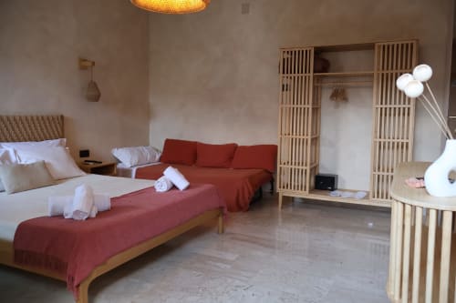 Moderno monolocale presso Tagasuites Catania con letto, divano, armadio in legno e arredi contemporanei