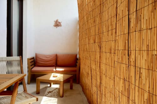 Accogliente zona living dell'appartamento Tagasuites Catania con divano in legno, tavolino da caffè e parete divisoria in bambù