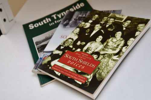 South Shields history books stacked on white surface at Love Short Stays hotel apartment