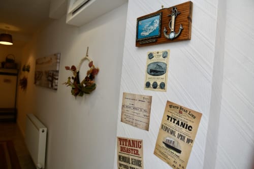 The Lower Deck apartment wall decorated with Titanic memorabilia, nautical anchor, and vintage maritime posters at Love Short