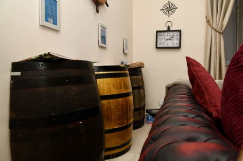 The Lower Deck apartment at Love Short Stays features vintage wooden barrels and nautical decor with comfortable seating