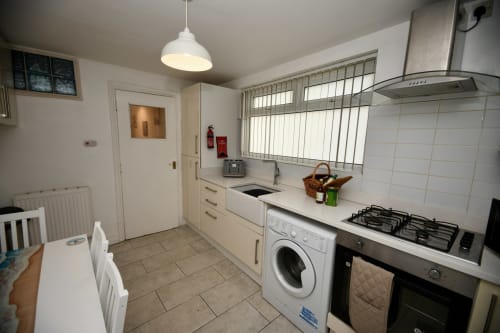 Modern kitchen in The Lower Deck apartment at Love Short Stays, South Shields, featuring gas cooktop, washing machine, and