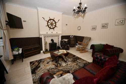The Lower Deck apartment living room at Love Short Stays South Shields with nautical decor, red velvet sofa, fireplace and