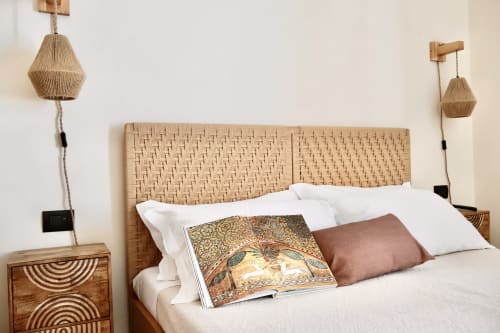 Letto con testata in rattan intrecciato, cuscini bianchi e decorativi alla Suite Deluxe di Tagasuites a Catania