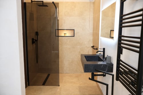 Lussuoso bagno Tagasuites Catania con lavabo in marmo nero, doccia walk-in, scaldasalviette e comfort premium