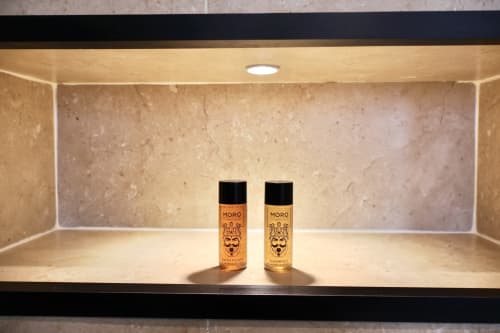 Prodotti da bagno MORO esposti su scaffale illuminato nel bagno della Suite Deluxe 109 di Tagasuites, Catania