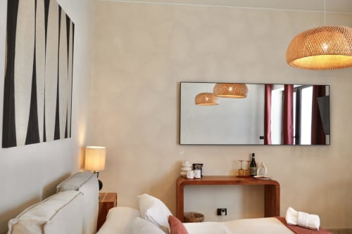 Modern hotel room at Tagasuites Catania with bed, woven pendant lights, mirror, and wooden desk
