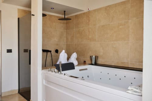 Luxury bathroom with whirlpool tub, rainfall shower, and heated towel rack at Tagasuites in Catania