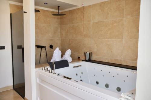 Luxurious jacuzzi bathtub with rainfall shower in modern Catania hotel bathroom