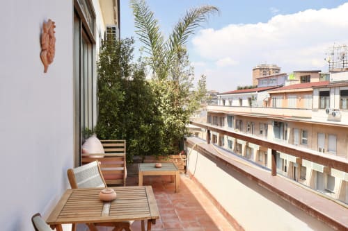 Tagasuites junior suite balcony in Catania with city views, wooden furniture, and potted plants
