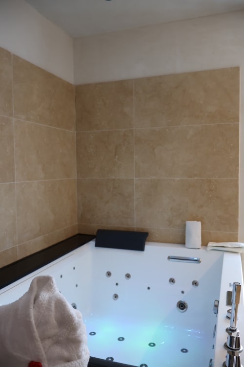 Luxury Jacuzzi bathtub with jets and blue lighting at Tagasuites junior suite in Catania, Italy