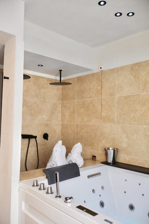 Luxury bathroom with whirlpool tub, rainfall shower, and heated towel rack at Tagasuites Catania