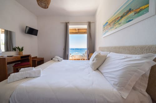 Camera moderna con vista mare, biancheria bianca, scrivania in legno e balcone sul Mediterraneo a Villa Bina Sea Hotel