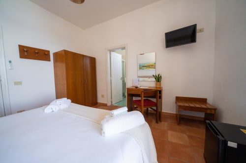 Spaziosa camera Superior a Villa Bina Sea Hotel con letti gemelli, armadio in legno, scrivania, TV e vista mare a Serrara Fontana