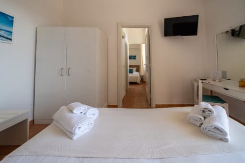 Camera da letto luminosa a Villa Bina Sea Hotel con letti gemelli, armadio, porta di comunicazione e vista mare a Serrara Fontana