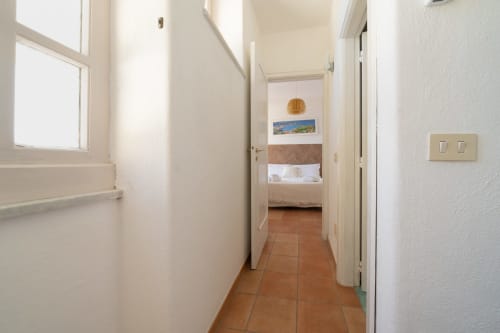 Luminoso corridoio con pavimenti in cotto che conduce alla camera da letto di Villa Bina Sea Hotel, Serrara Fontana, Italia