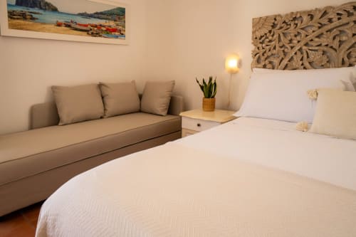 Camera Suite con vista mare al Villa Bina Sea Hotel, letto matrimoniale, divano e opere d'arte con tema marino a Serrara Fontana, Italia