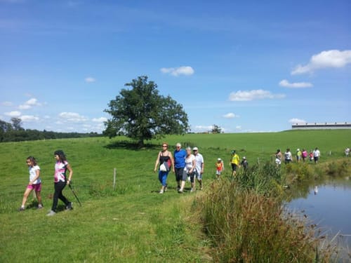 Groupe de jogging dans les champs verdoyants près de Châlus, France, avec paysage rural et ruisseau
