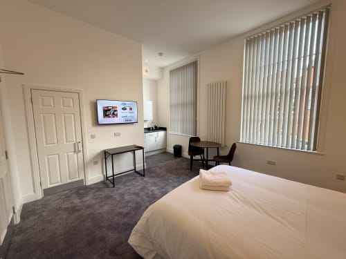 Fishergate Residences Preston deluxe studio with king size bed, Smart TV, desk, dining area and vertical blinds