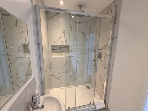 Modern shower enclosure with marble-effect tiling at Fishergate Residences Deluxe Studio, Preston