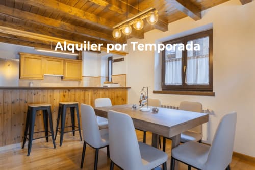 Comedor moderno con vigas de madera, encimera de cocina y vistas a las montañas en Betrén