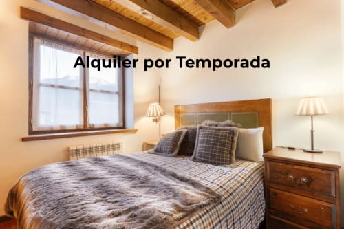 Dormitorio acogedor en apartamento Casau con vigas de madera, cama queen, vistas a la montaña y decoración rústica para alquiler a corto plazo