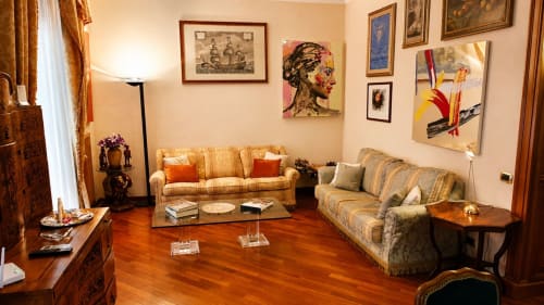 Elegant living room in Myob apartment, Rome, with striped sofas, wooden floors, and gallery wall art