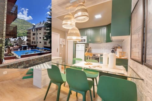 Apartamento moderno en Vielha con cocina verde, comedor, lámparas de mimbre y vistas de la estación de esquí de los Pirineos