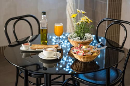 Mesa de desayuno en Hotel La Posada con café, jugo, pasteles, aceite de oliva y margaritas frescas en Cartagena