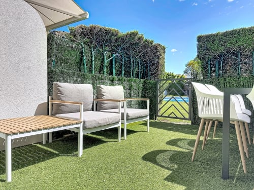 Terraza de cabaña moderna en Estartit con zona de estar, setos cuidados y patio jardín soleado en L'Estartit