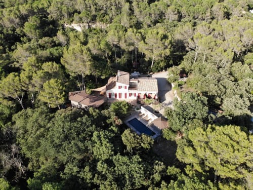 Vue aérienne de la villa Domaine d'Olga à Aniane avec piscine, entourée de verdure luxuriante et forêt