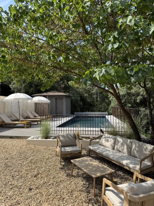 Espace piscine de luxe au Domaine d'Olga avec coin détente, parasols et vue sur le jardin verdoyant à Aniane, France