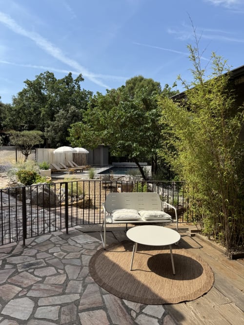 Terrasse de jardin paisible à la villa Domaine d'Olga à Aniane avec coin détente, vue sur piscine et paysagisme luxuriant