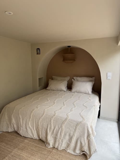 Alcôve chambre avec niche voûtée à la villa Domaine d'Olga à Aniane, literie crème et luminaire suspendu