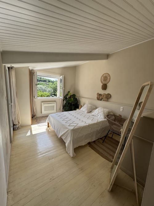 Chambre lumineuse de la villa Domaine d'Olga avec vue sur le jardin, parquet et équipements modernes à Aniane