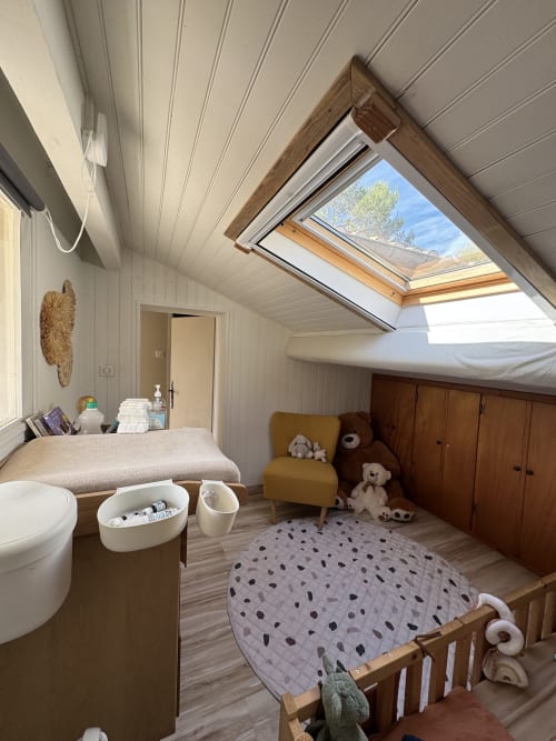Chambre douillette sous les combles avec puits de lumière à la Villa Domaine d'Olga à Aniane, avec lit, fauteuil, rangements et poutres en bois
